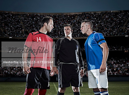 Soccer players facing each other on field