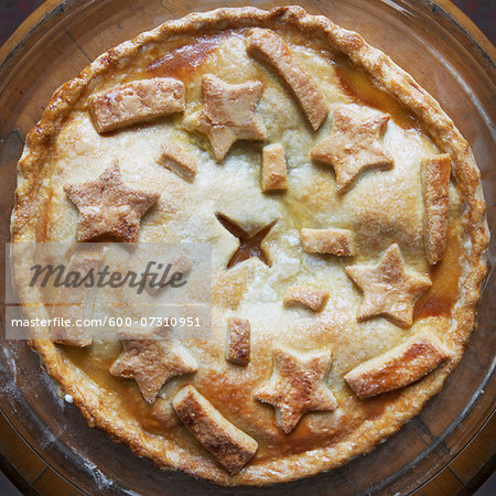 Overhead view of freshly baked apple pie with star shaped cut-outs on top, studio shot