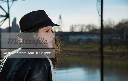 Close-up portrait of teenage girl outdoors, wearing fedora and looking into the distance, Germany