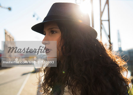 Close-up portrait of teenage girl outdoors, wearing fedora and looking into the distance, Germany