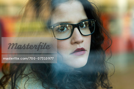 Close-up portrait of teenage girl wearing eyeglasses and looking out window, Germany