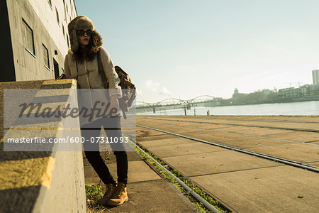 Teenage girl outdoors, wearing trapper hat and sunglasses, standing next to building at loading dock, Mannheim, Germany Teenage girl outdoors, wearing trapper hat and sunglasses, standing next to building at loading dock, Mannheim, Germany