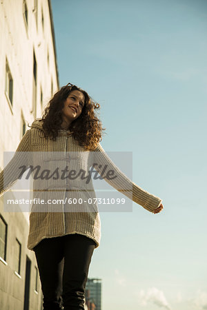 Teenage girl outdoors, standing next to building at loading dock, Germany