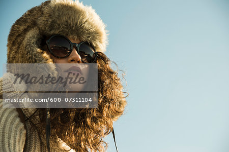 Close-up portrait of teenage girl outdoors, wearing trapper hat and sunglasses, Germany