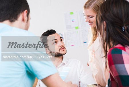 Close-up of group of young business people meeting and in discussion in office, Germany