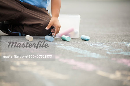 Boy Drawing on Sidewalk with Chalk