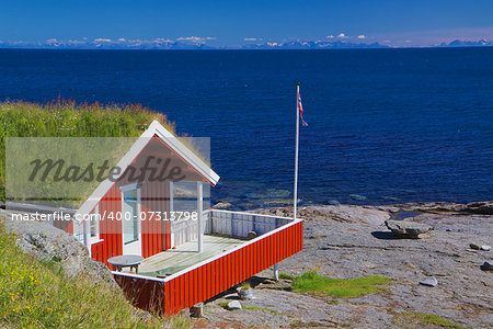 Typical red holiday hut with sod roof on Lofoten islands in Norway