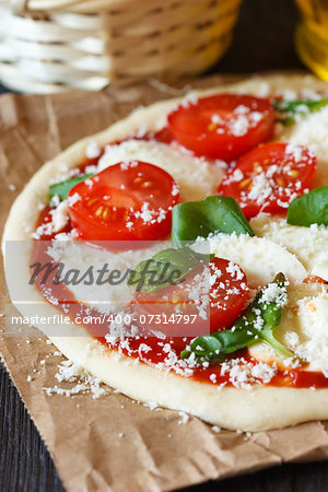 Rustic italian pizza with mozzarella, tomatoes and basil close-up.