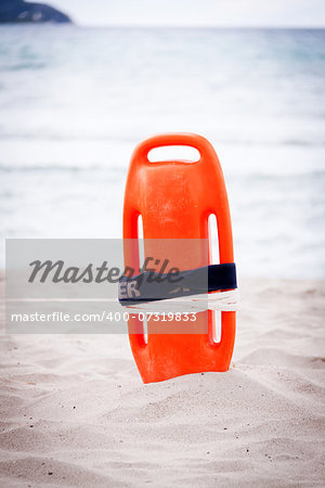 orange red life buoy in sand on beach at the sea object summertime