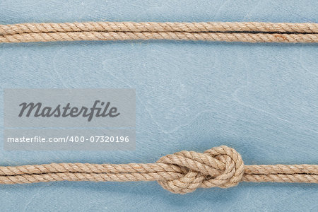 Ship rope knot on blue wooden texture background