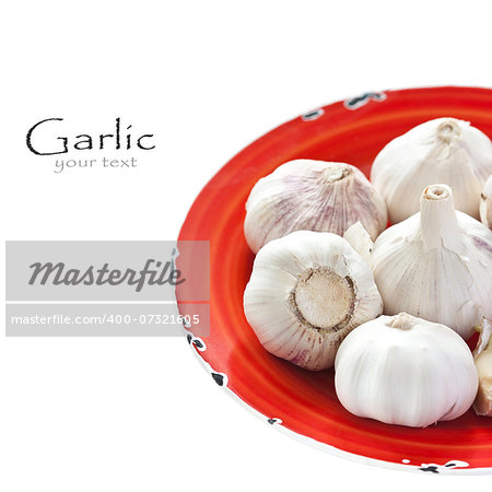 Garlic on a red rustic plate.