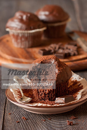 Delicious chocolate muffins with spoon and chocolate bar close-up.