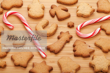 Various gingerbread cookies with candy cane on wooden table background