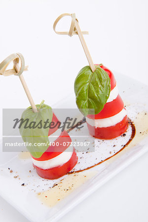 tasty tomatoe mozarella salad with basil isolated on white background