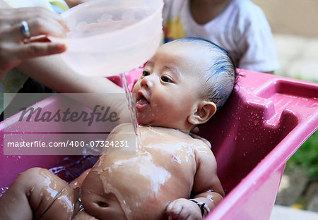 Mom washes young son. Indonesia, Bali