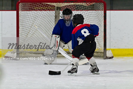 Young ice hockey player prepares to shoot on net