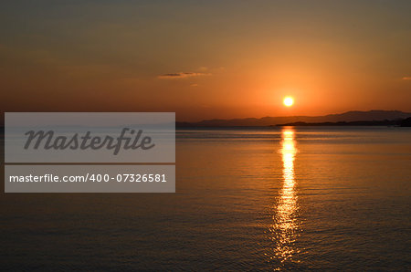 Tropical sunset at Nagura Bay at the japanese island Ishigaki. In the background is the island Iriomote.