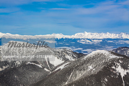 Aerial view of snowy mountains on sunny day in cold winter