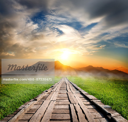 Wooden road in the mountains at sunset