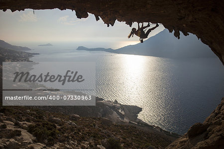 Family rock climber against picturesque view of Telendos Island at sunset. Kalymnos Island, Greece.