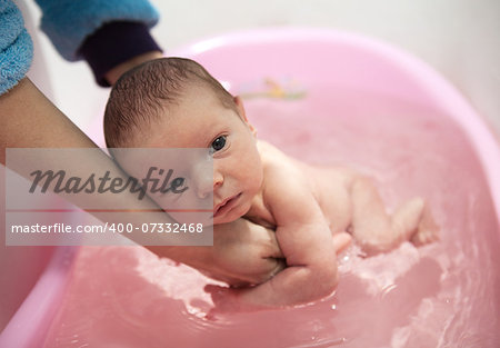 Mom bathing cute baby boy