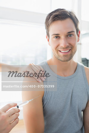 Portrait of happy man being injected by doctor in hospital