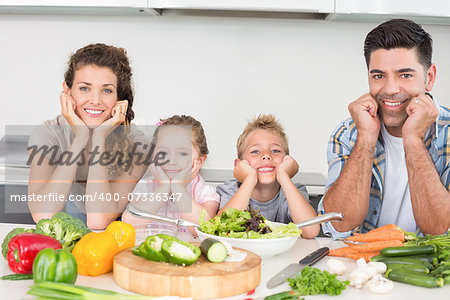 Cheerful family preparing vegetables together at home in kitchen