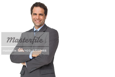Handsome businessman smiling at camera with arms crossed on white background