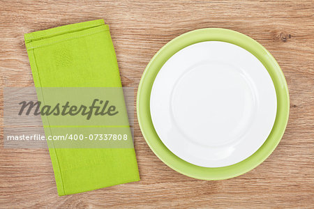 Empty green plates with towel over wooden table