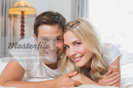 Portrait of a relaxed happy casual young couple resting in bed at home