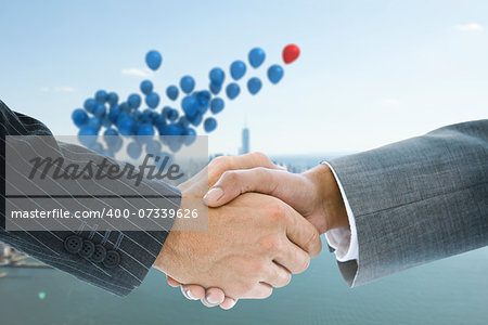 Composite image of business handshake against balloons above coastline