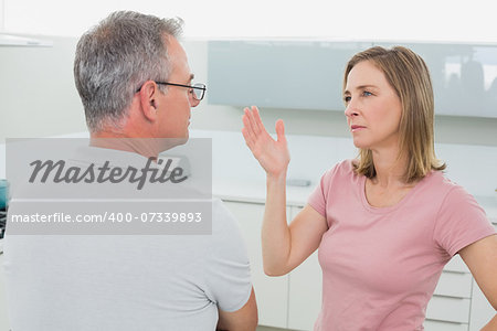 Unhappy couple having an argument in the kitchen at home