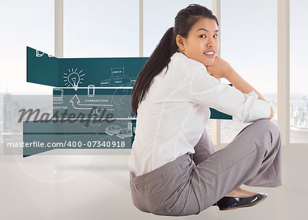 Businesswoman sitting cross legged smiling against bright white room with windows