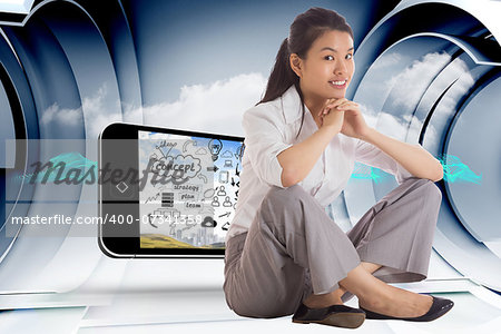 Smiling businesswoman sitting with hands together against abstract blue cloud design in futuristic structure