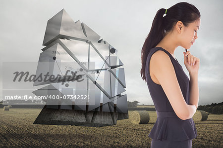 Thinking businesswoman against landscape with bales of straw