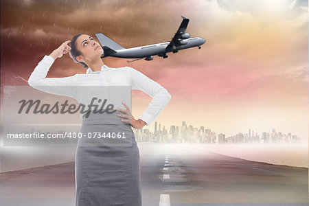 Focused businesswoman against road leading out to the horizon