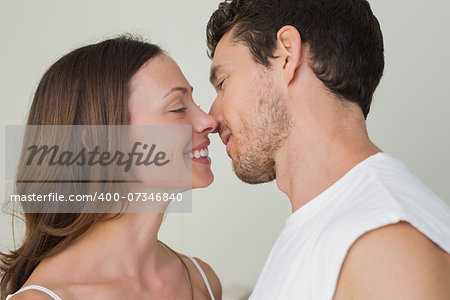 Side view of a loving young couple about to kiss at home