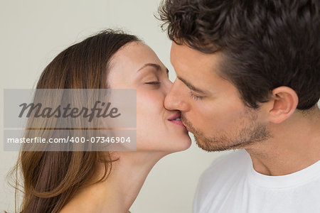 Side view of a loving young couple kissing at home