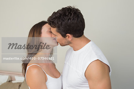 Side view of a loving young couple kissing at home