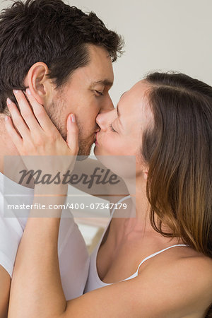 Side view of a loving young couple kissing at home