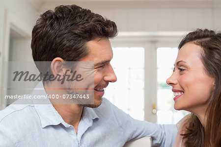Side view of a loving young couple looking at each other at home