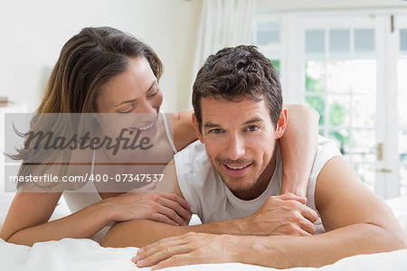 Portrait of a relaxed young couple lying in bed at home