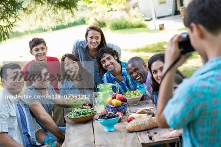 A summer party outdoors. Adults and children posing for a photograph.