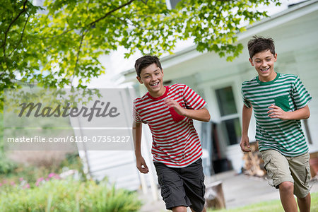 Two boys in a farmhouse garden in summer.