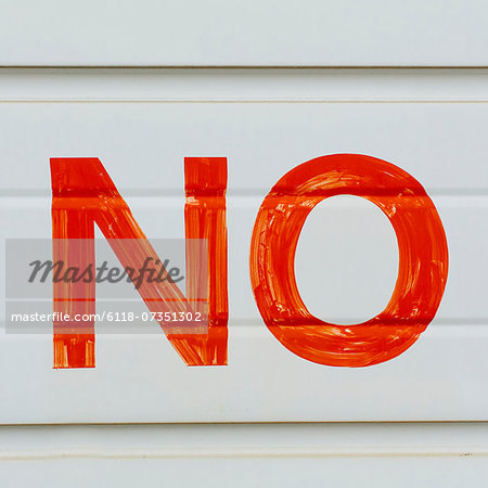 A large NO sign in red paint on a garage door, indicating No Parking.