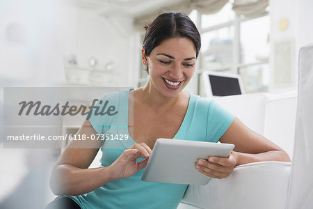 Business people. The office in summer. A young woman sitting comfortably in a quiet airy office environment. Using a digital tablet.