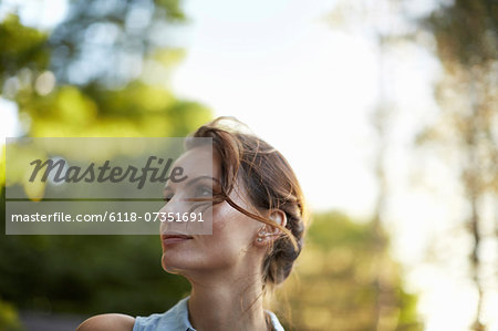 A young woman in the woods at dusk.