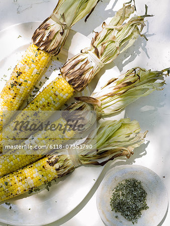 A buffet table set up in a garden for al  fresco meal. Sweetcorn, grilled corn on the cob.
