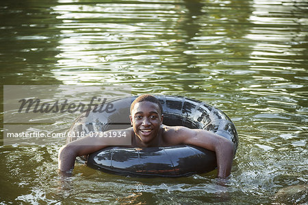 A boy floating in the water using a tyre swim float.