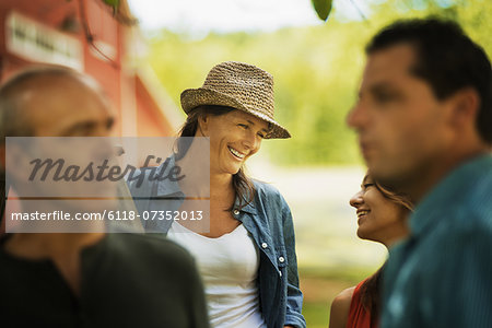 Four people in a farmyard on a traditional farm in the USA.